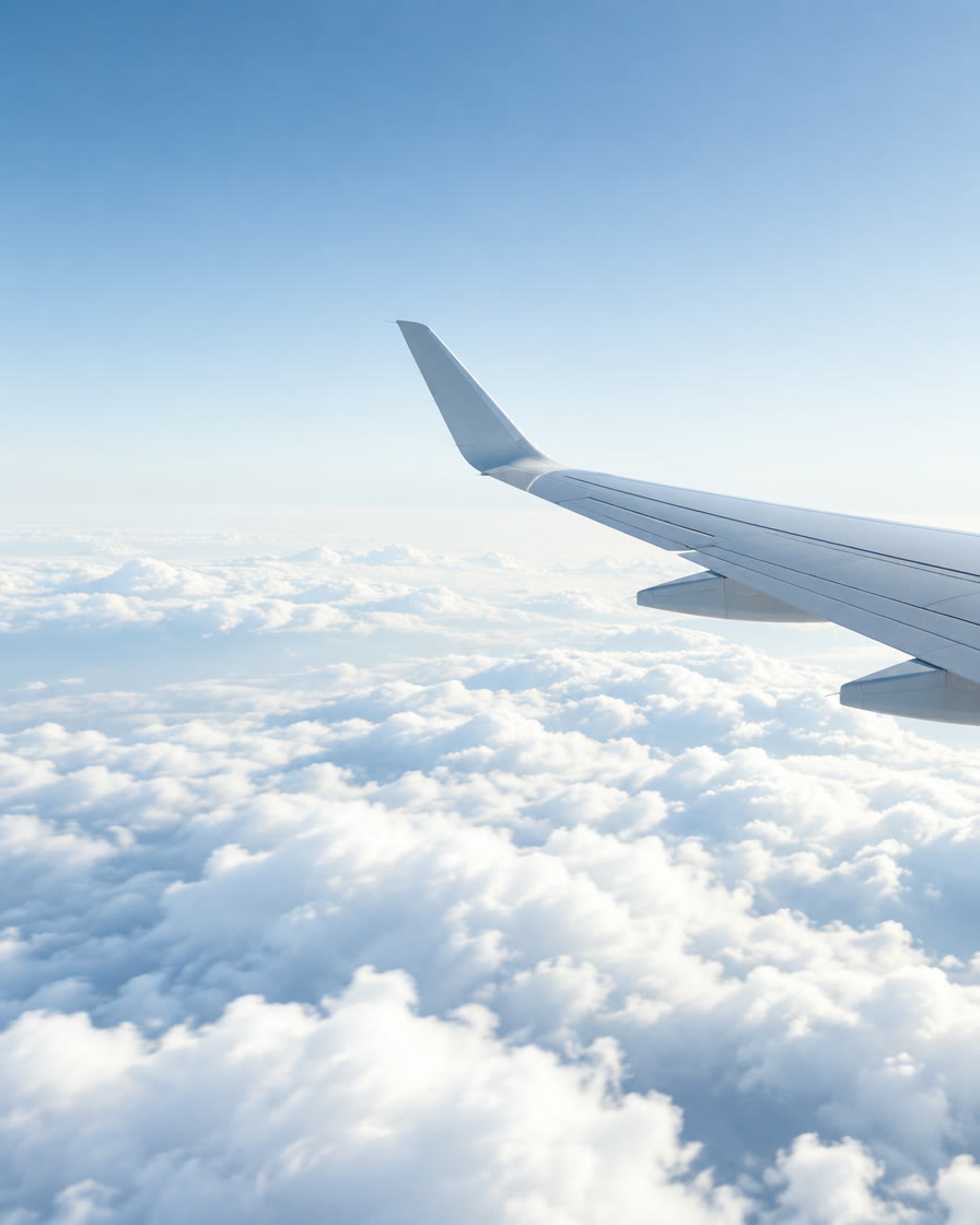 Airplane wing above a sea of clouds